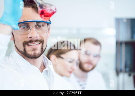 Analytical Chemist analyzing a red solution that looks promising Stock Photo