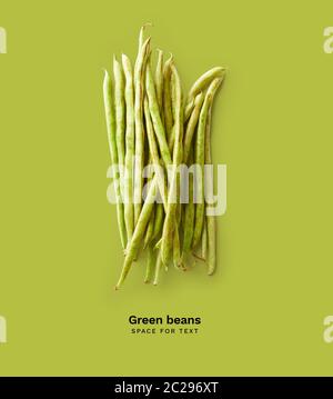 Creative layout with isolated green beans on green background. Top view with copy space. Healthy vegetarian food concept Stock Photo