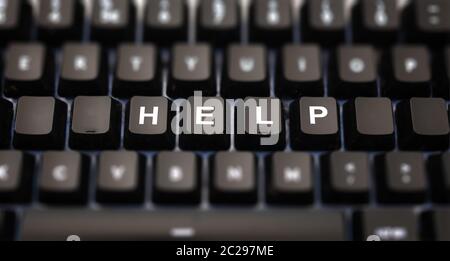 Help text written on computer keypad. Black keys with white letters message for assistance on pc keyboard. Blur buttons background. Stock Photo