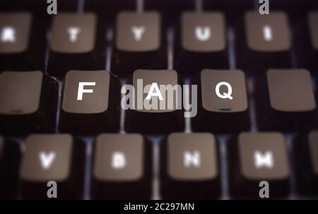 Faq word written on computer keypad. Black keys with white letters message for assistance on pc keyboard. Blur buttons background. Help online concept Stock Photo