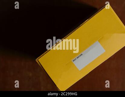 Selective focus on white paper label attached to a box with message BEST BEFORE, copy space for product expiry date Stock Photo