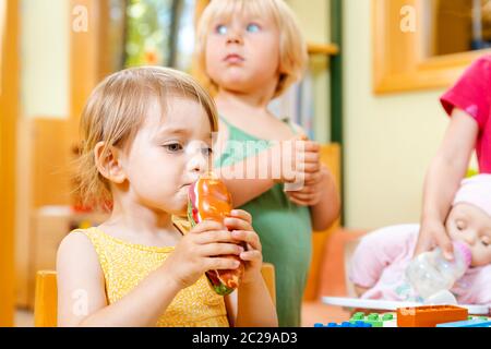 Children eating some food in play school biting in sandwich Stock Photo