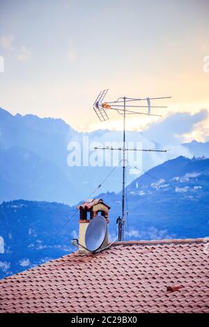 TV Antenna on the roof of an Italian house, Sunset Stock Photo