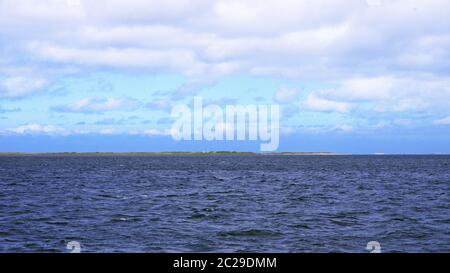 Horizont auf See mit Meer und Wolken am Himmel und Land in der Weite Stock Photo
