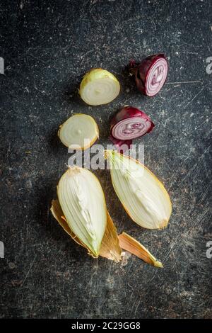 Halved fresh bulbs on old kitchen table. Top view. Stock Photo