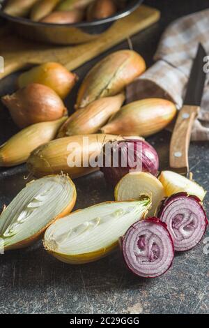 Halved fresh bulbs on old kitchen table. Stock Photo