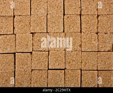 Close up background texture pattern of brown cane sugar cubes arranged Stock Photo
