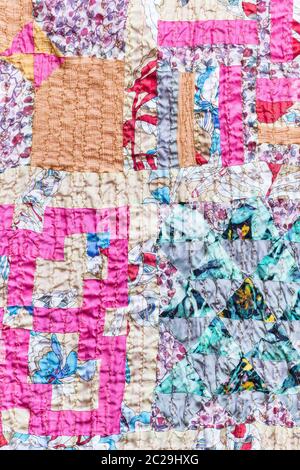 textile background - textured patchwork scarf stitched from various silk strips and crushed pink cotton fabric Stock Photo