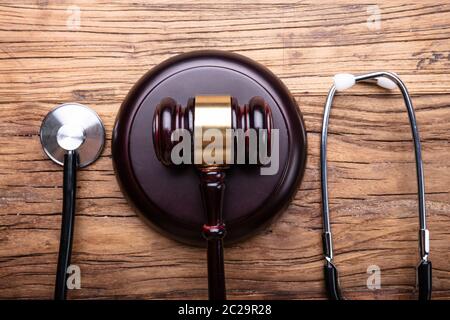 High Angle View Of Gavel With Stethoscope Arranged On Wooden Table Stock Photo