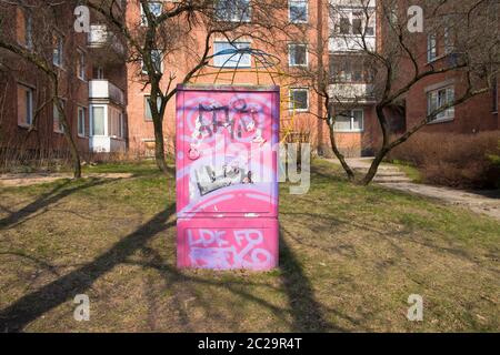 A brightly painted pink electrical utility box in a courtyard of old, communist era apartments. In Vilnius,  Lithuania. Stock Photo