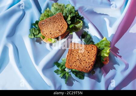 Pieces of rye bread with various greens on a drapery, concept of healthy sandwich, selective focus Stock Photo