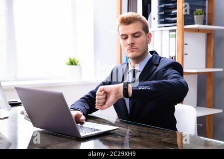 Efficient Businessman Looking At Watch Checking Time Stock Photo