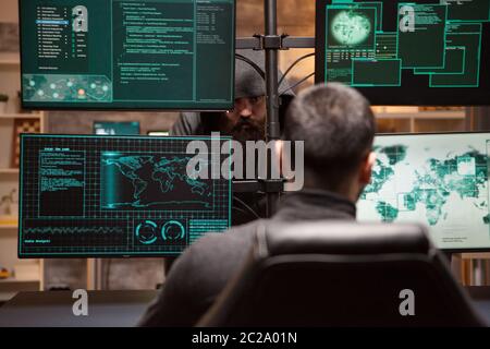 Two male hackers hacking into bank to steal credit card identity. Hackers technology. Stock Photo