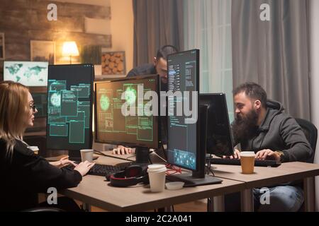 Organised hackers in a room with computers stealing online informations. Stock Photo