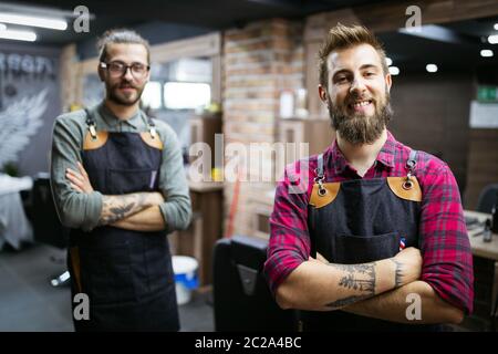 Portrait of young male barbers and hairdressers in barber shop Stock Photo