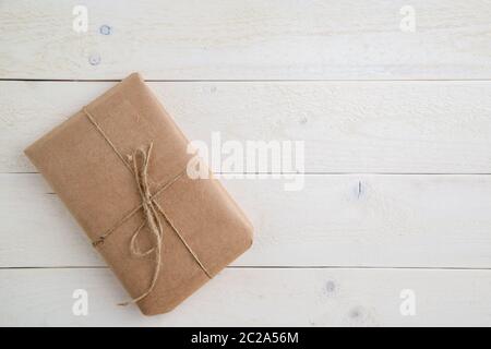 parcel,gift Packed in eco-friendly paper on light wooden background. the view from the top Stock Photo