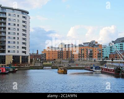 a view of the lock gates at leeds dock with a yellow water taxi and houseboats moored along the dockside Stock Photo