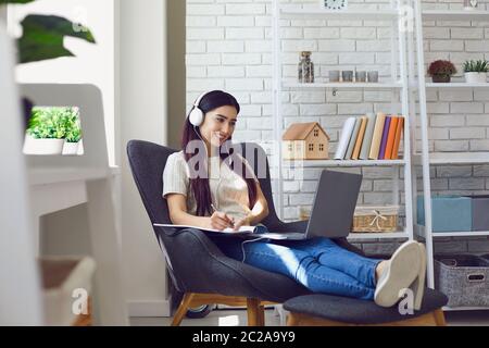 Young woman student attend online class, webinar or internet lecture from home using laptop computer Stock Photo