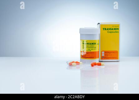 CHONBURI, THAILAND-MAY 24, 2020 : Transamin capsules with drug bottle and paper box with label package on gradient background. Orange-yellow capsule Stock Photo