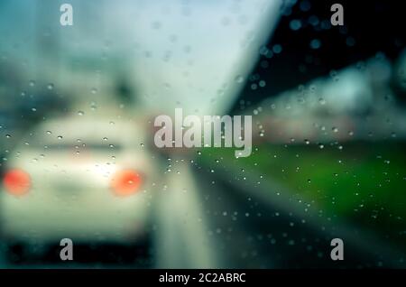 Rain drops on windshield. Car driving on asphalt road on rainy day. Windshield window of car with raindrops on glass windscreen. Traffic jam on rainy Stock Photo