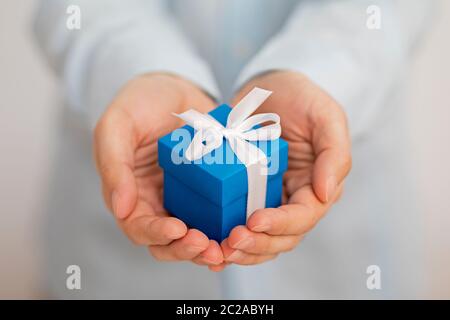 Small blue present box in hands Stock Photo