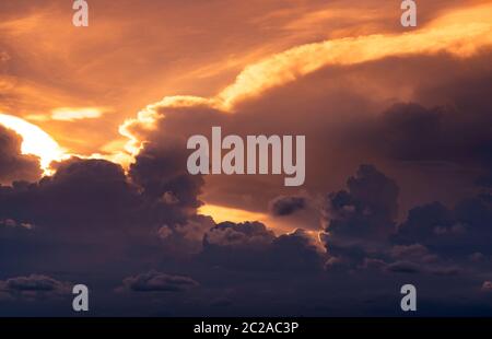 Sunset sky. Golden light shine in layers of clouds. Fluffy clouds at dusk. Twilight sky. God light. Cloudscape. Beauty in nature. Art picture of sky Stock Photo