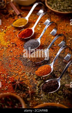 Different spices in spoons on table. Still life of spices and herbs Stock Photo