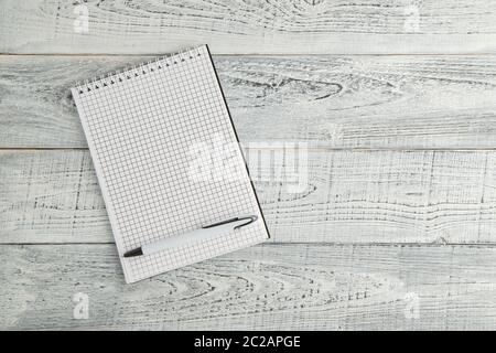 white paper Notepad and white pen on vintage shabby white wooden background Stock Photo