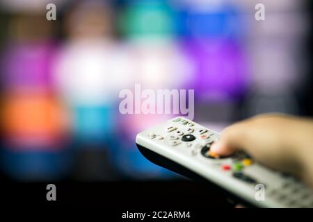 Remote control in hand in from of smart tv Stock Photo