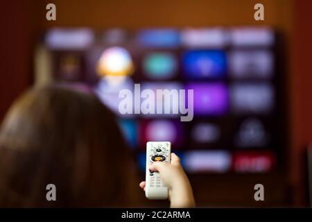 Remote control in hand in from of smart tv Stock Photo