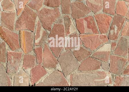 Wall surface with decorative mosaic of natural stone broken tiles as granite breccia background. Stock Photo