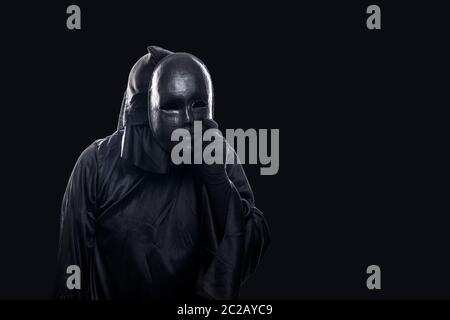 Scary figure with black mask in hooded cloak Stock Photo - Alamy