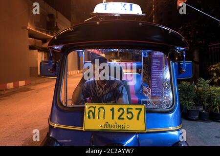 Tuk tuk traditional taxi illuminated at night, on the streets of Chang Mai . Stock Photo