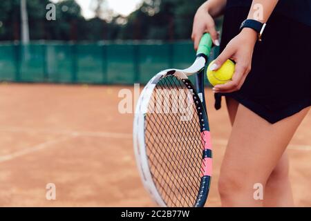 Tennis player. Close-up view of young woman ready to hit a tennis ball. Playing on the court. Stock Photo