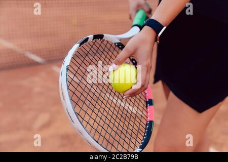 Tennis player. Close-up view of women's hand preparing to hit a ball, playing tennis on the court. Stock Photo