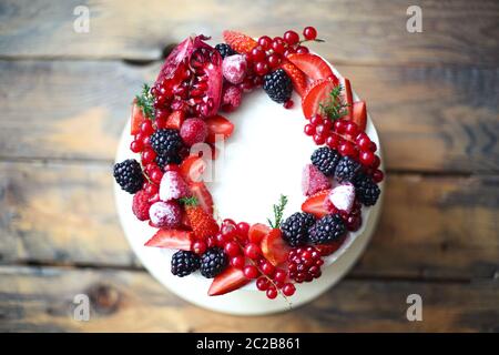 Christmas Cake decorated with berries on the wooden table Stock Photo