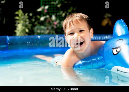 Happy laughing toddler boy having fun in a swimming pool