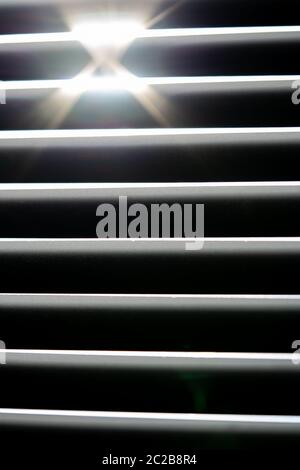 Thin lines of light on the wall. Shadow from the blinds. bathroom. Stock Photo