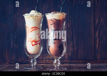 Two glasses of milkshake on the wooden background