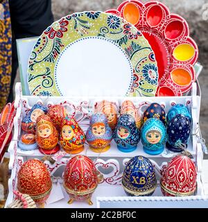 Ceramic plates, hand-painted wooden souvenirs are on the counter at the festive fair. Stock Photo