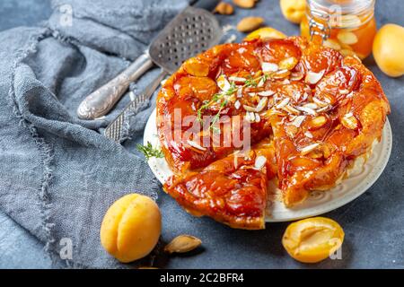 Apricot and almond tarte tatin on a white plate. Stock Photo