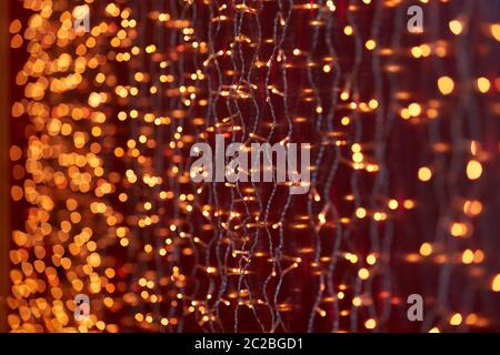 Festive background with LED lights garland. Christmas and New Year background. Blurred bokeh from the lights of a garland. Stock Photo