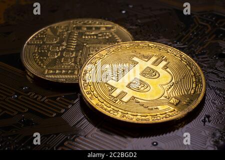 Two Bitcoin coins and printed circuit board PCB Stock Photo
