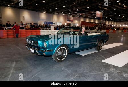 A 1965 Ford Mustang Convertible, driving down the Grand Avenue, during the 2019 London Classic Car Show Stock Photo