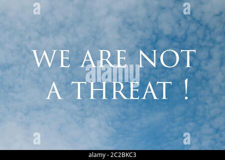 No Racism. Stop Racism. We are not a threat Sign with Dramatic Clouds and Sky. Stock Photo