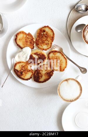 Breakfast Table Set. Traditional Homemade Syrniki and Coffee Overhead. Stay Home Concept. Stock Photo