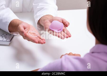 Gynecologist Showing Contraception Ring And Diaphragm To Woman And Explaining Contraception And Birth Control Methods Stock Photo