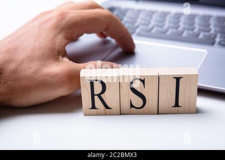 Man Working On Laptop With Repetitive Strain Injury Syndrome Letters Stock Photo