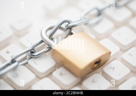 Security concept with metal padlock and chain on computer keyboard Stock Photo