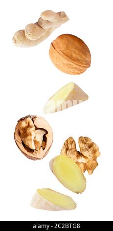 Isolated flying fruit. Falling walnuts fruits and ginger roots isolated on white background with clipping path as package design element and advertisi Stock Photo